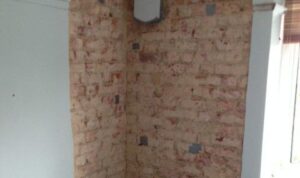 Wall being dried by dehumidifier